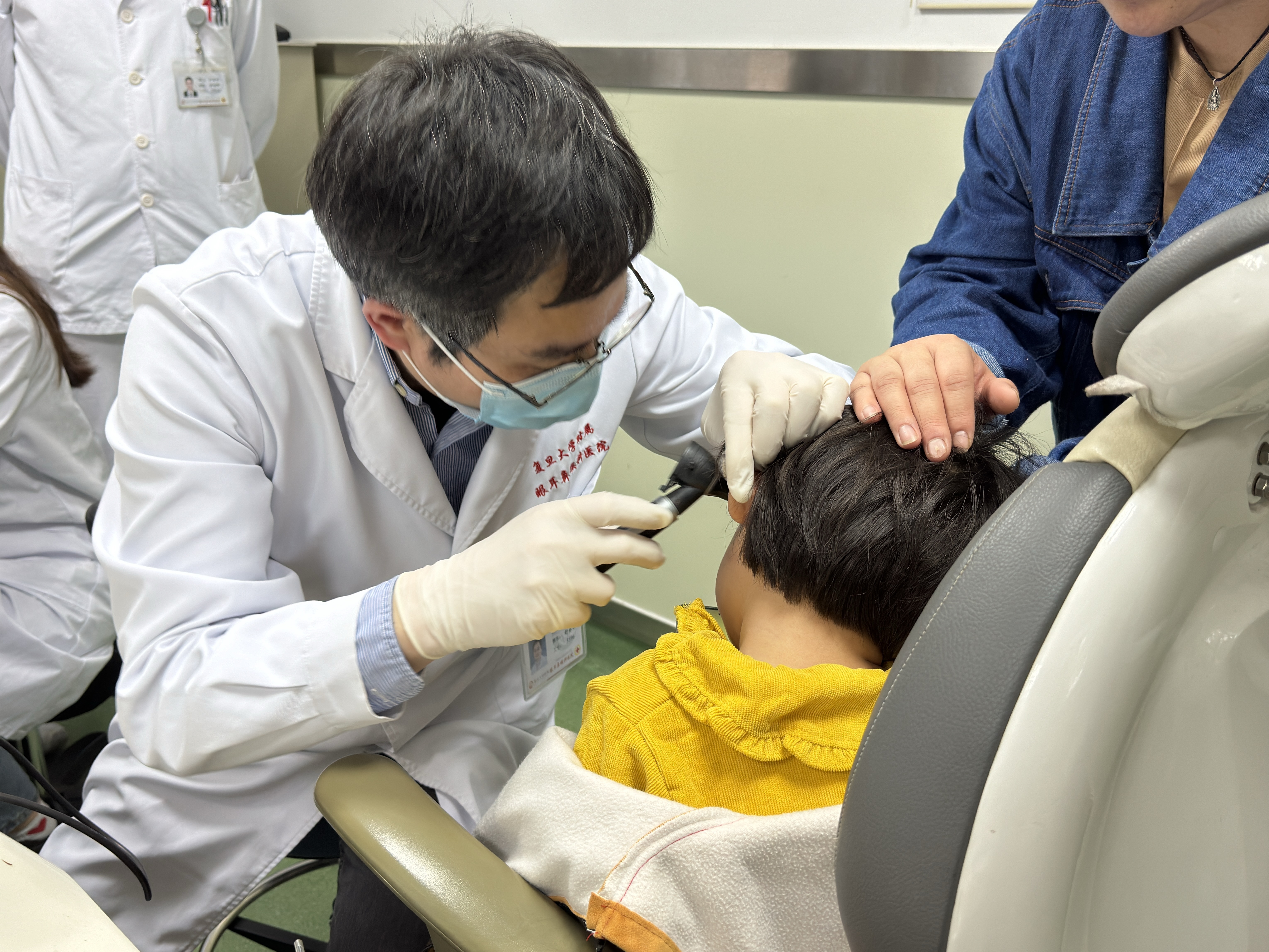 caption: Dr. Yilai Shu examines a young patient at the Eye &amp; ENT Hospital of Fudan University in China.