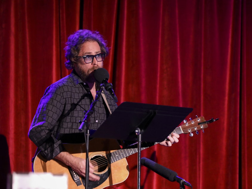 caption: <em>Ask Me Another</em>'s house musician Jonathan Coulton leads a music parody game at the Bell House in Brooklyn, New York.