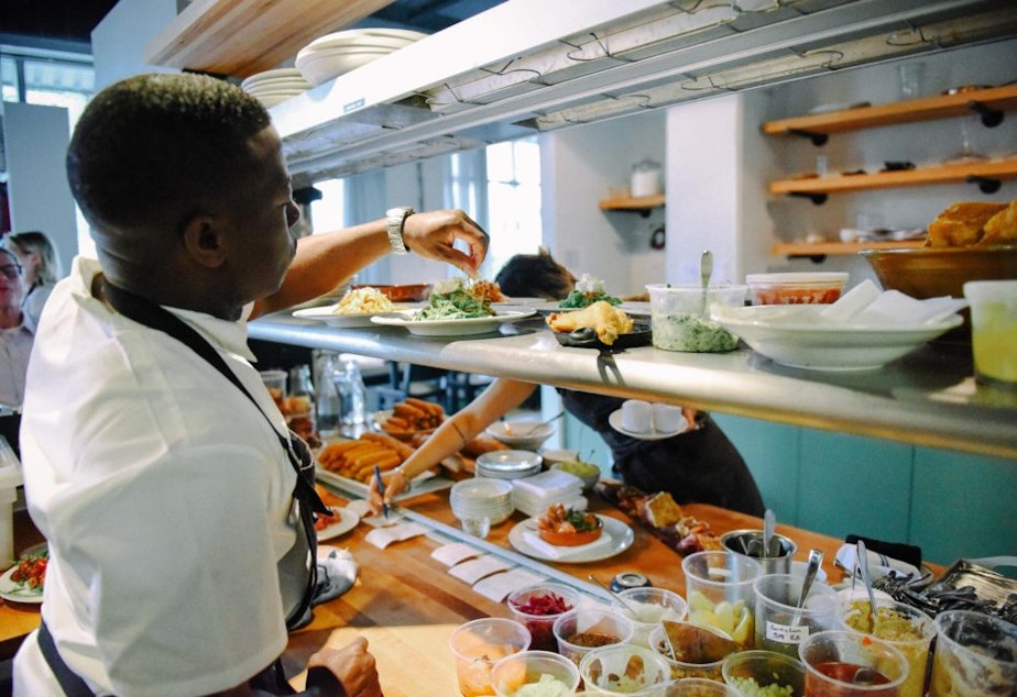 caption: James Beard Award-winnng Chef Edouardo Jordan adds garnish to a dish at Salare in Seattle.