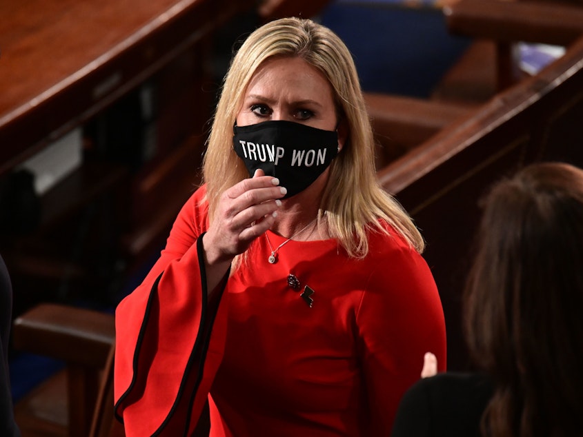 caption: Rep. Marjorie Taylor Greene, R-Ga., wears a "Trump Won" face mask as she arrives on the floor of the House to take her oath of office as a newly elected member of the House of Representatives on Jan. 3.