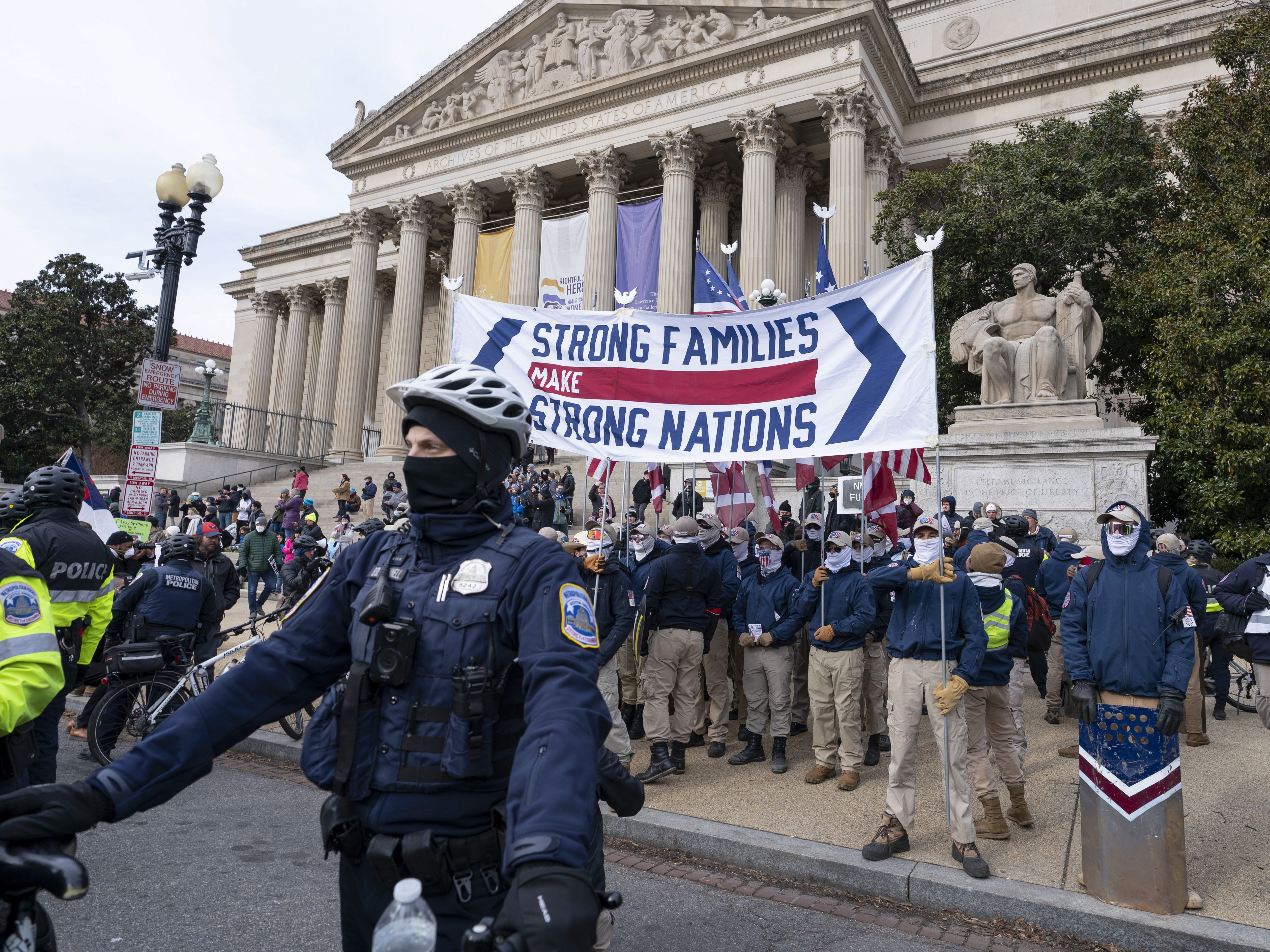 caption: Members of the white supremacist group Patriot Front march on Constitution Avenue near the National Archives in Washington in January.
