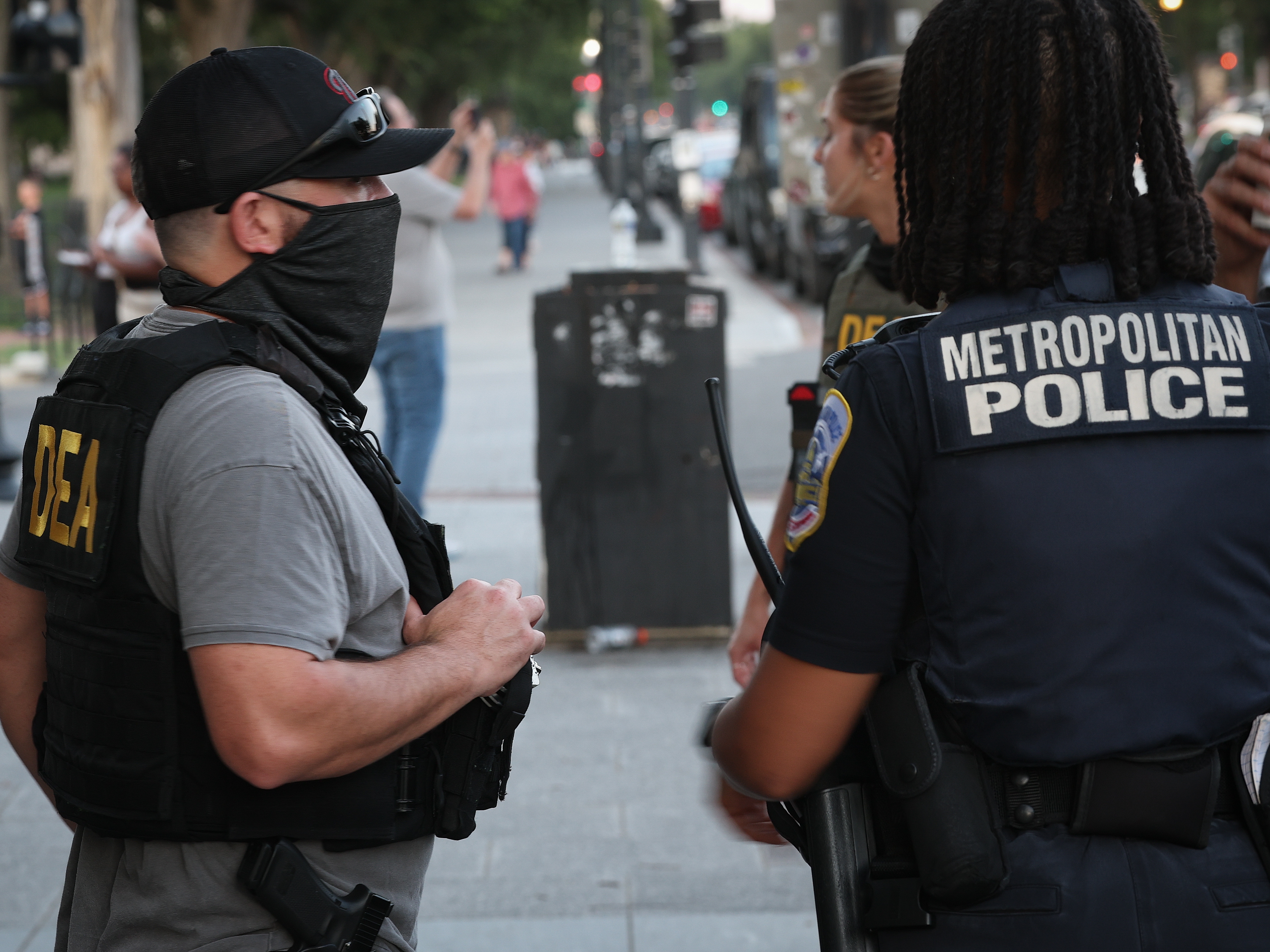 caption: A U.S. Drug Enforcement Administration agent talks with a Metropolitan Police Department officer while patrolling near the Washington Monument on the National Mall on Monday. President Trump announced a federal takeover of D.C. Metro police and mobilization of the National Guard, saying the moves are necessary to restoring order in the city.