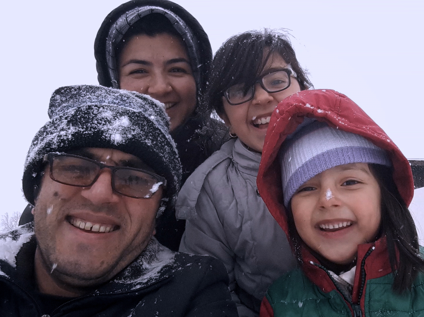 caption: Afghan filmmaker Hassan Fazili (bottom left) and his wife, filmmaker Fatima Hussaini (top left), with their daughters, Nargis (top right) and Zahra.