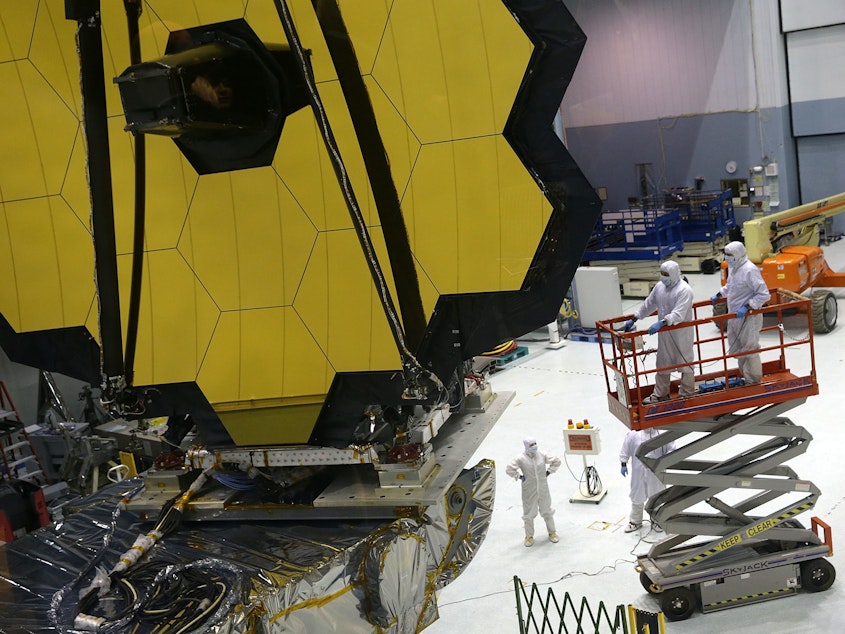 caption: Technicians work on NASA's James Webb Space Telescope, which will launch in December. Astronomers say the next big telescope should be designed to search signs of life on planets that orbit distant stars.