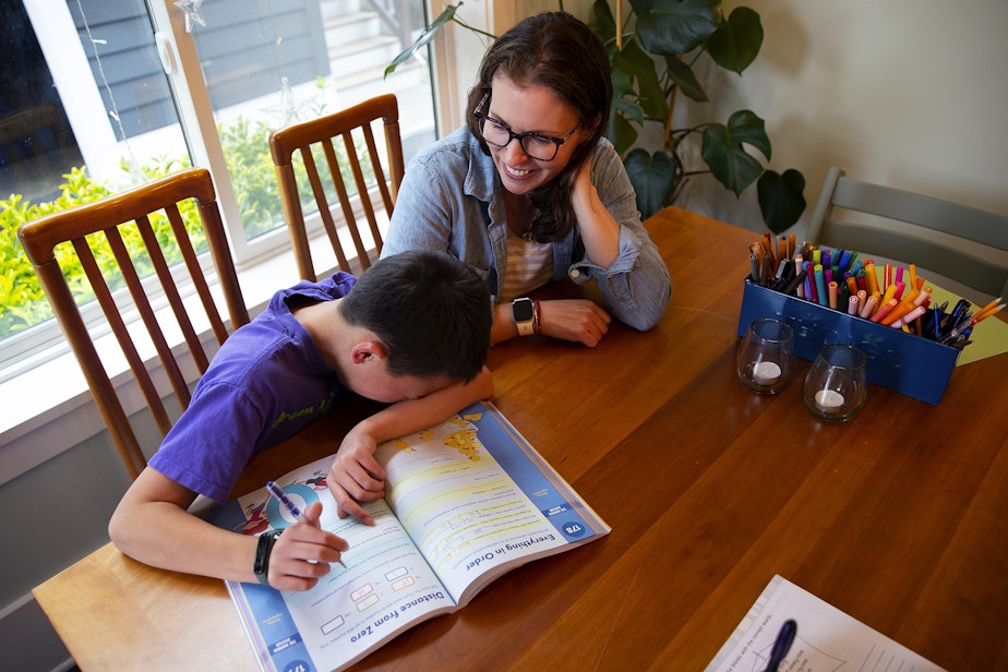 caption: Kadie Bell Sata laughs with her son, who is in fifth grade, while doing math work after school on Monday, June 3, 2024, in Seattle. 