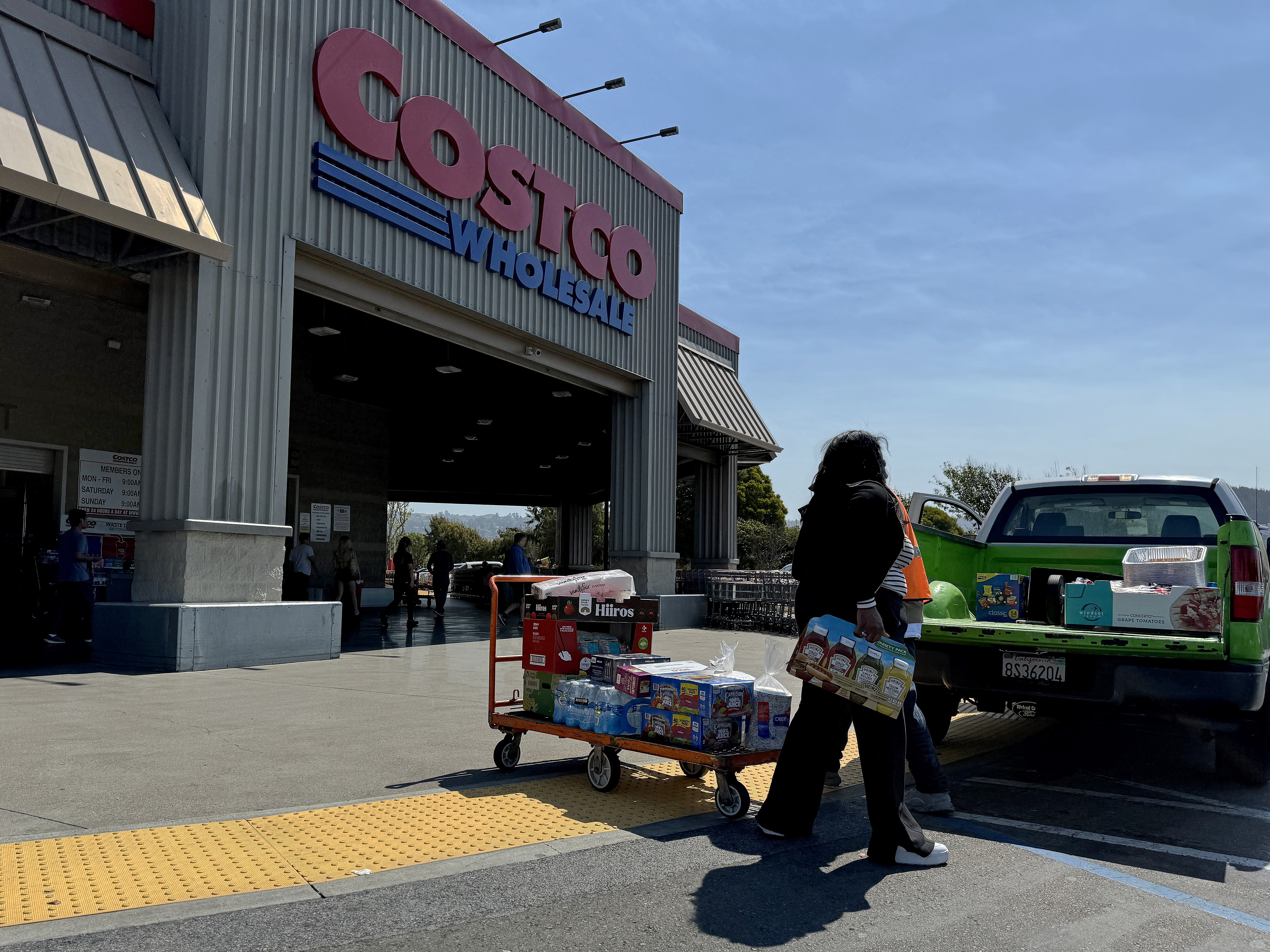 caption: A customer loads a pickup truck after shopping at a Costco store on July 11 in Richmond, Calif.