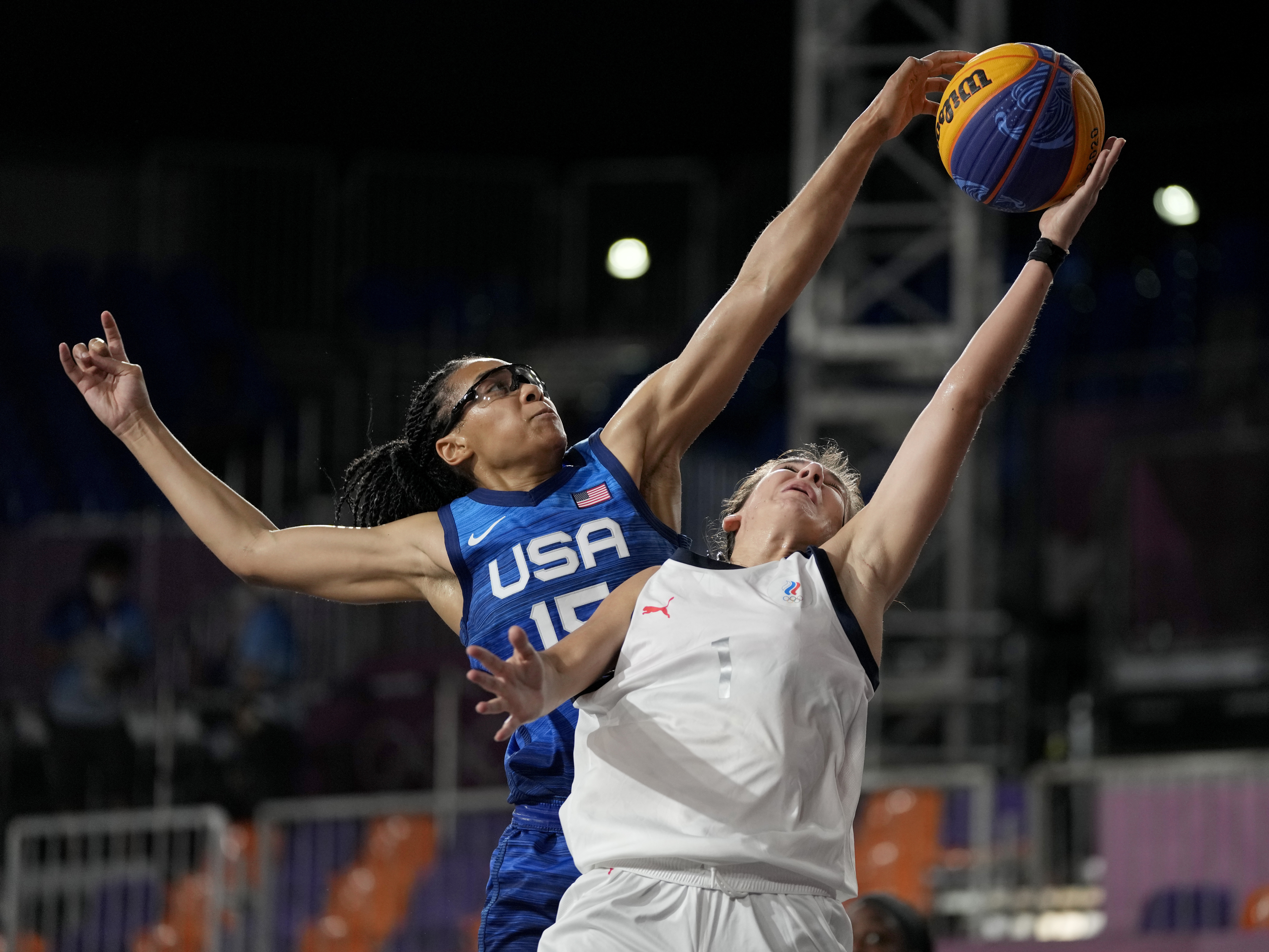 caption: U.S. player Allisha Gray blocks a shot by Yulia Kozik from Russia on Sunday during a women's 3-on-3 basketball game at the 2020 Summer Olympics in Tokyo.