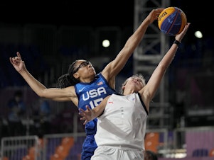 caption: U.S. player Allisha Gray blocks a shot by Yulia Kozik from Russia on Sunday during a women's 3-on-3 basketball game at the 2020 Summer Olympics in Tokyo.