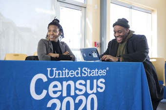 caption: Chris Worrell jokes with Teresa Jefferson while applying for a 2020 census job in Boston in February before the COVID-19 pandemic. Based on government records, the Census Bureau estimates the U.S. population has grown by as much as 8.7% since 2010.