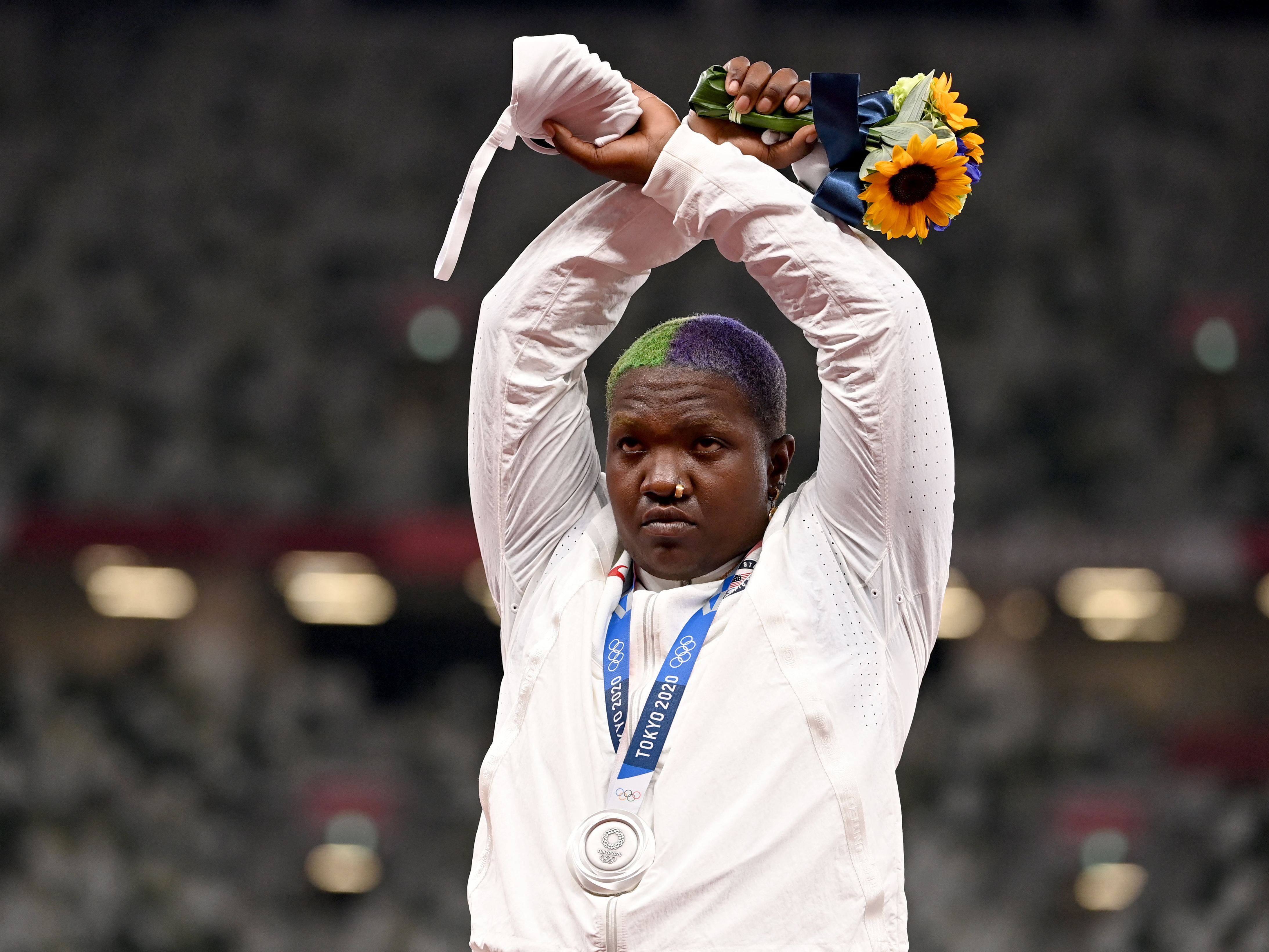 caption: Second-placed USA's Raven Saunders gestures on the podium with her silver medal after competing the women's shot put event during the Tokyo 2020 Olympic Games at the Olympic Stadium in Tokyo on Sunday.