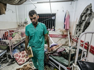 caption: A man inspects the damage in a room following Israeli bombardment at Nasser Hospital in Khan Younis, southern Gaza Strip, on Dec. 17.