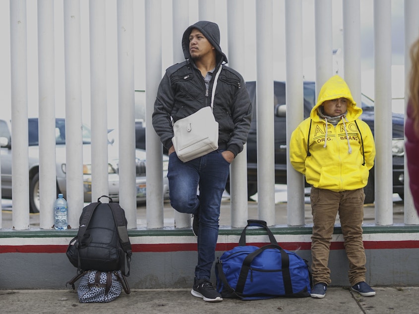 caption: Honduran migrants wait in line to plead their asylum cases earlier this month at a border crossing in Tijuana, Mexico.
