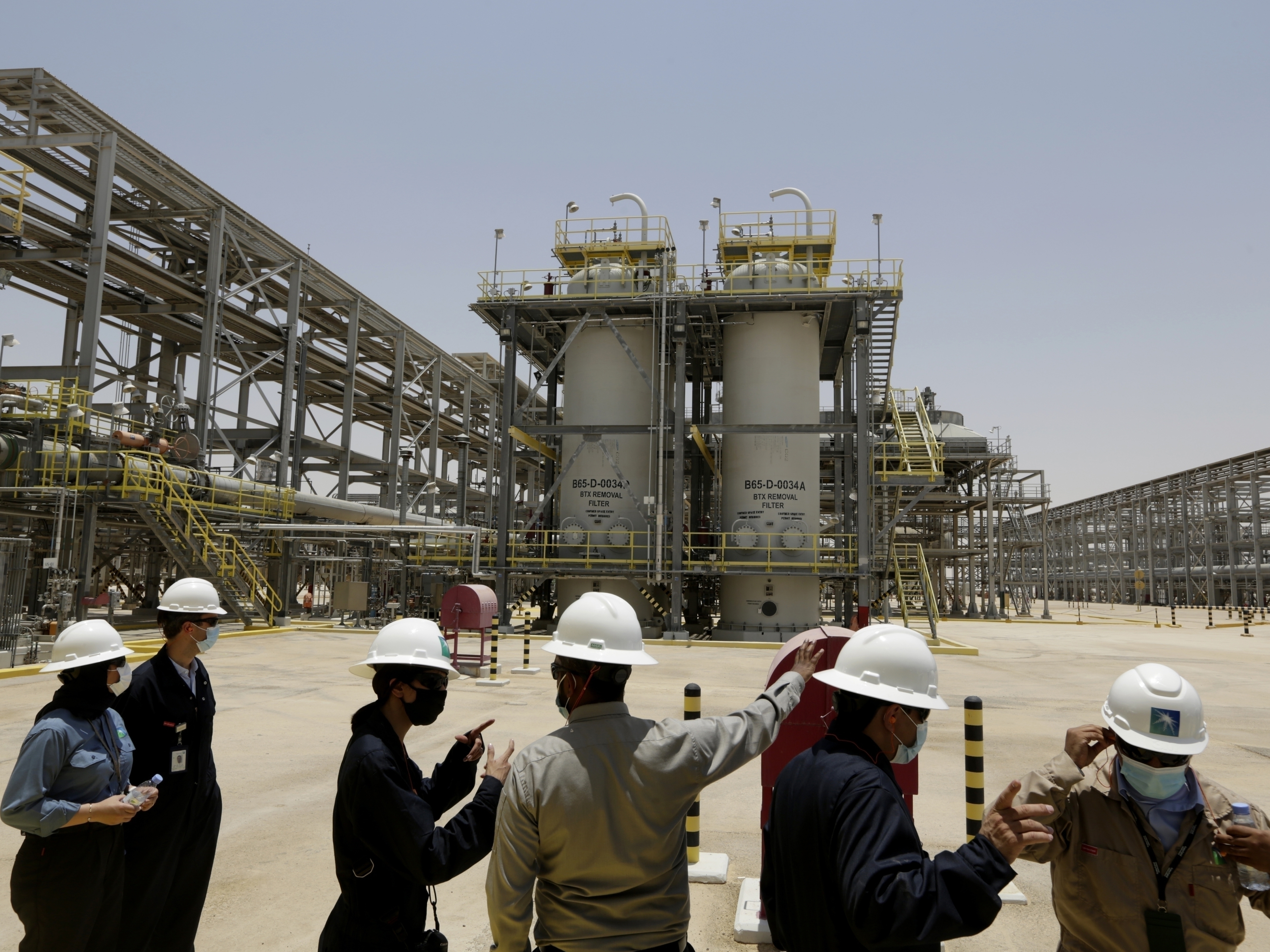 caption: Saudi Aramco engineers and journalists look at the Hawiyah Natural Gas Liquids Recovery Plant in Hawiyah, in the Eastern Province of Saudi Arabia in 2021.