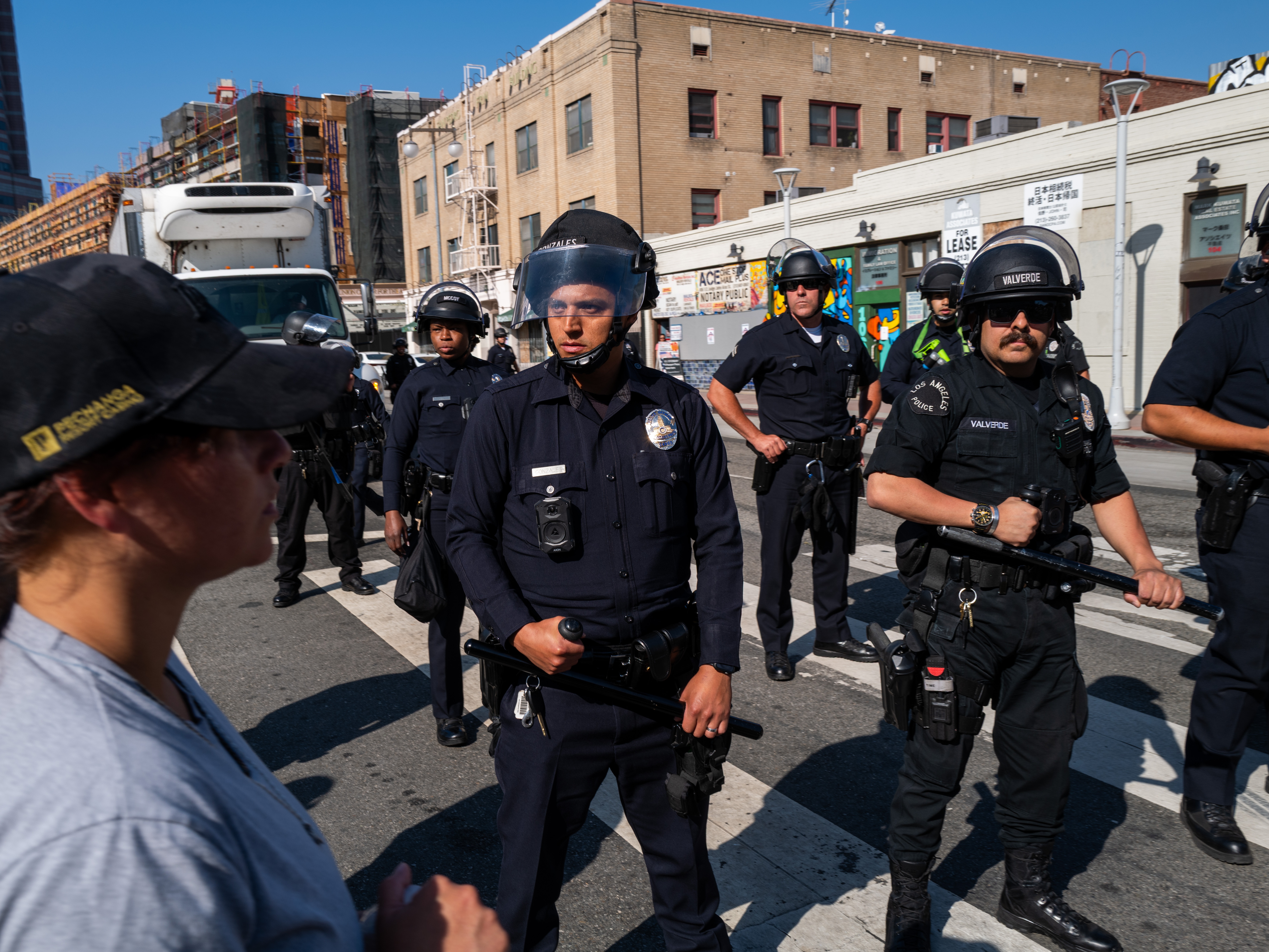 caption: Police monitor participants in an anti-ICE rally in downtown Los Angeles last week. Press advocates say law enforcement officials have violated journalists' rights as they cover the rallies. Some journalists say they believe they have been targeted by police officers seeking to intimidate them from reporting on what is happening there.