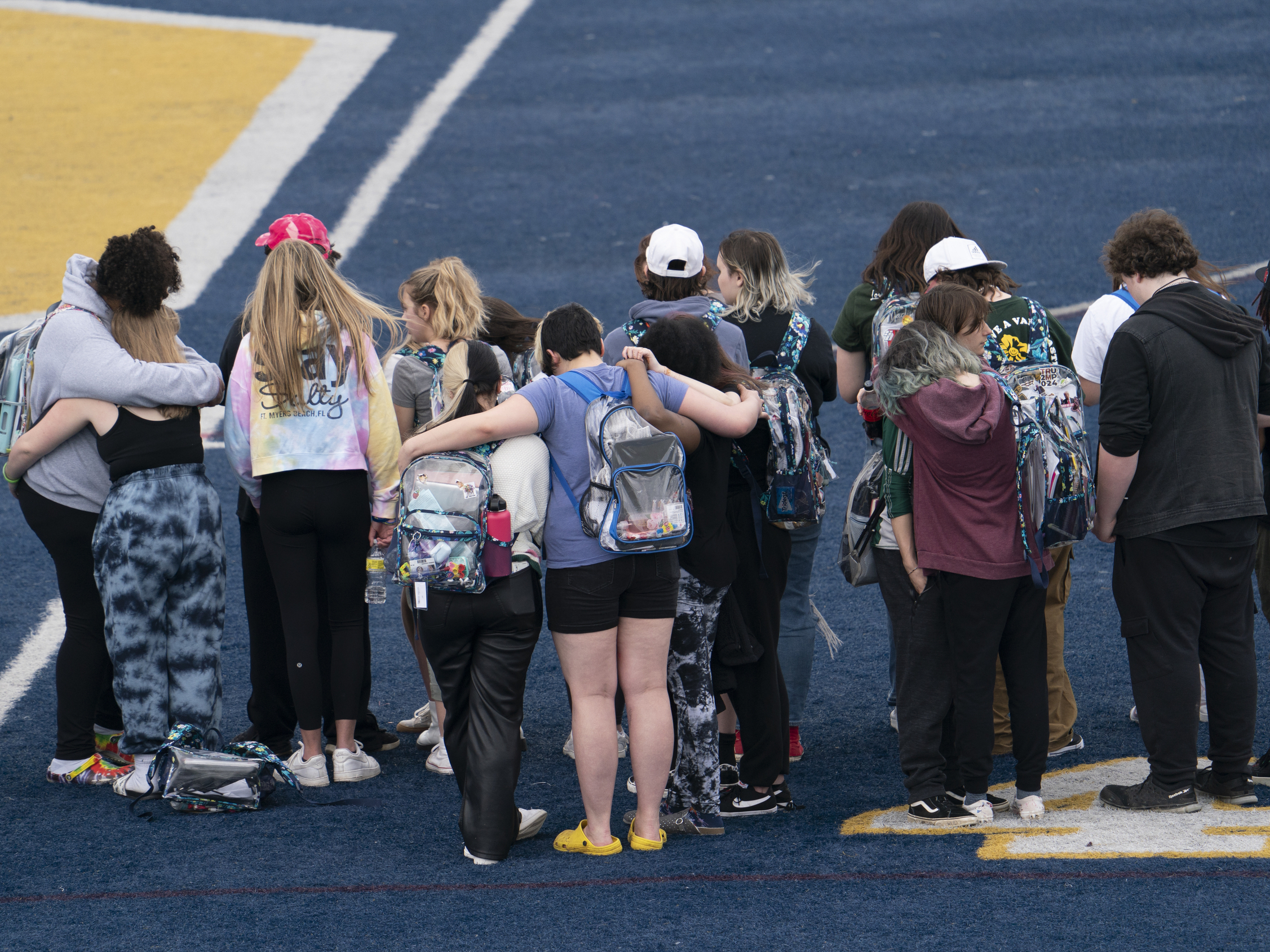caption: Oxford High School students embrace each other during Thursday's walkout.