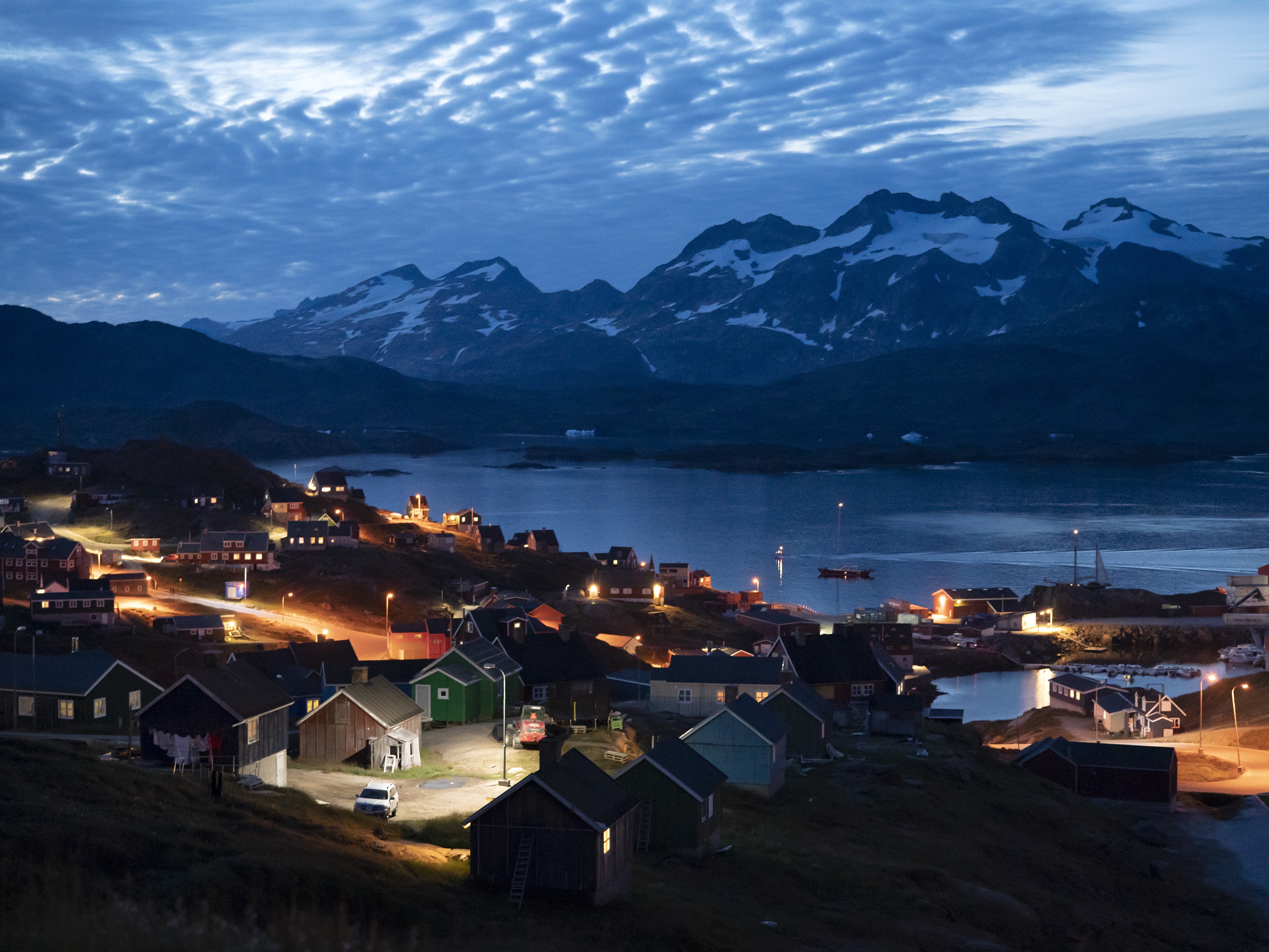 caption: Homes are illuminated after the sunset in Tasiilaq, Greenland, Friday Aug. 16, 2019.