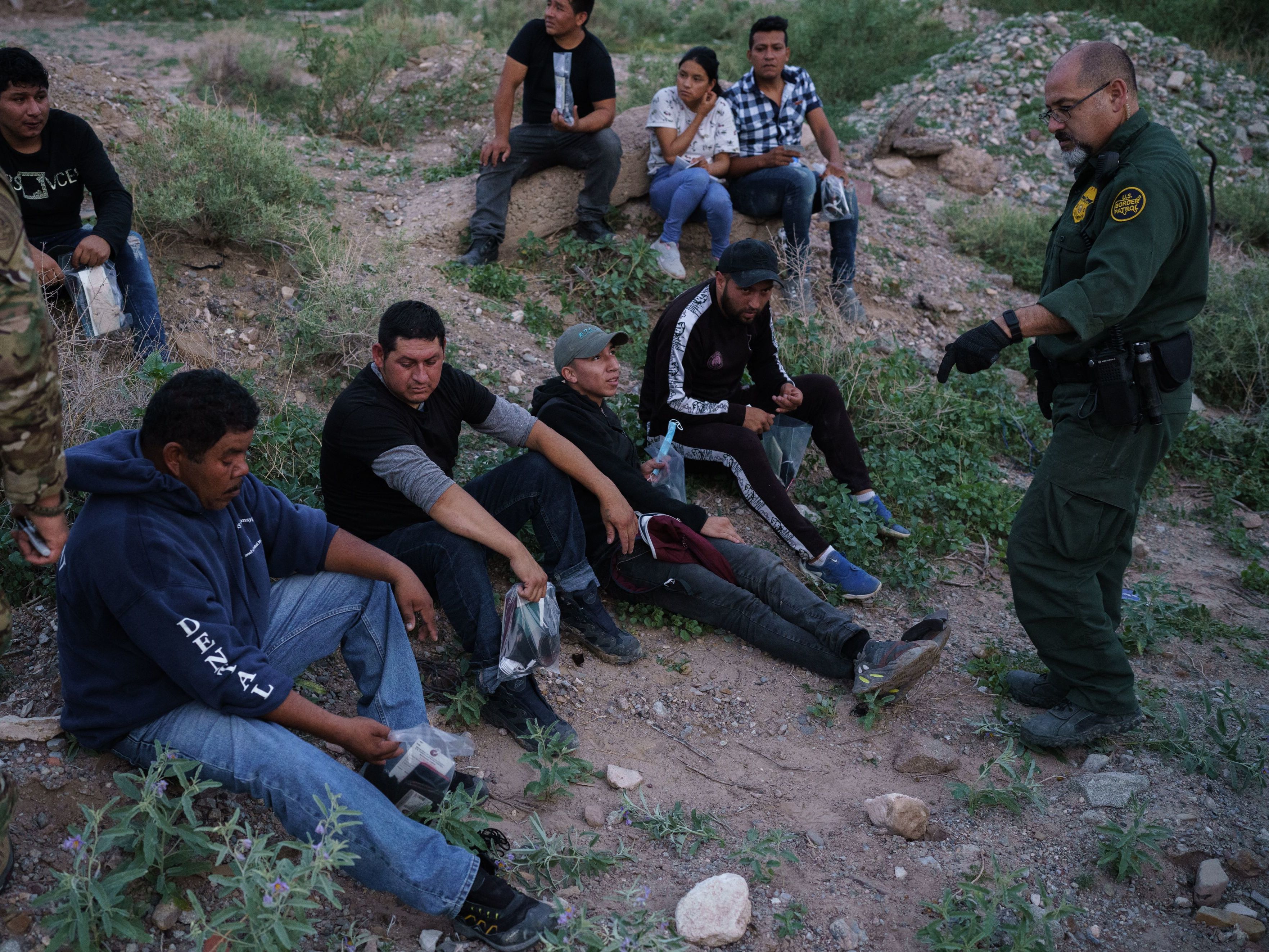 caption: A U.S. Border Patrol agent processes a group of migrants in Sunland Park, New Mexico. Democratic lawmakers and immigrant advocates are urging President Biden to end Title 42 border restrictions.