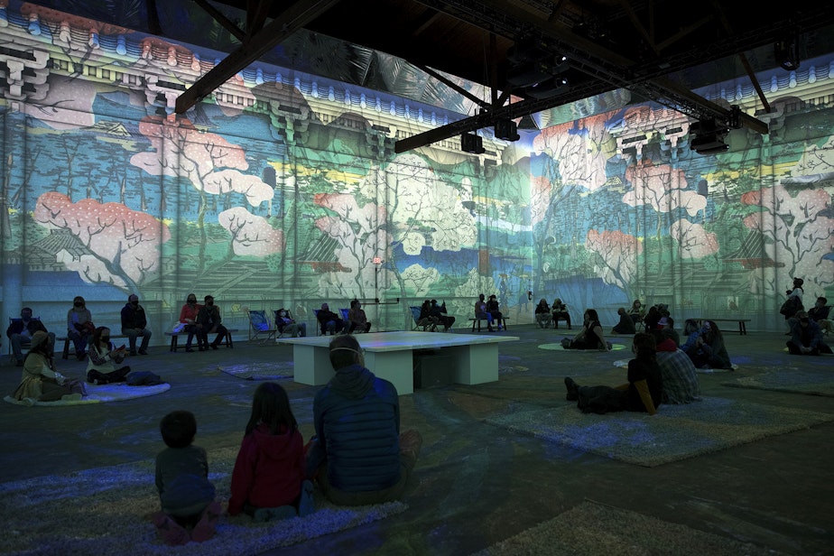 caption: Patrons take in various projections of Van Gogh's work in the 360-degree 8,000 square foot immersive room on Wednesday, October 27, 2021, at the exhibit along Occidental Avenue in Seattle's SODO neighborhood.