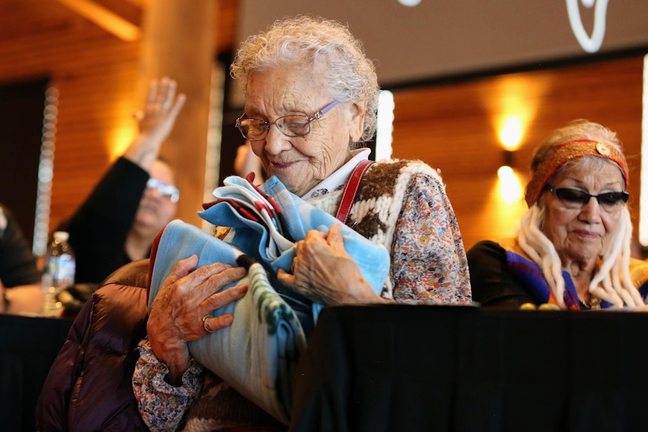 caption: Ernestine Lane from the Lummi Nation receives a gift after sharing  her experiences at the Tulalip Gathering Hall on Sunday in Tulalip. 