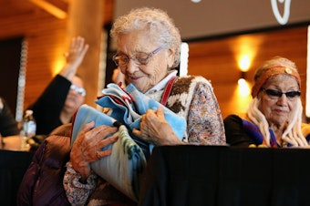 caption: Ernestine Lane from the Lummi Nation receives a gift after sharing  her experiences at the Tulalip Gathering Hall on Sunday in Tulalip. 
