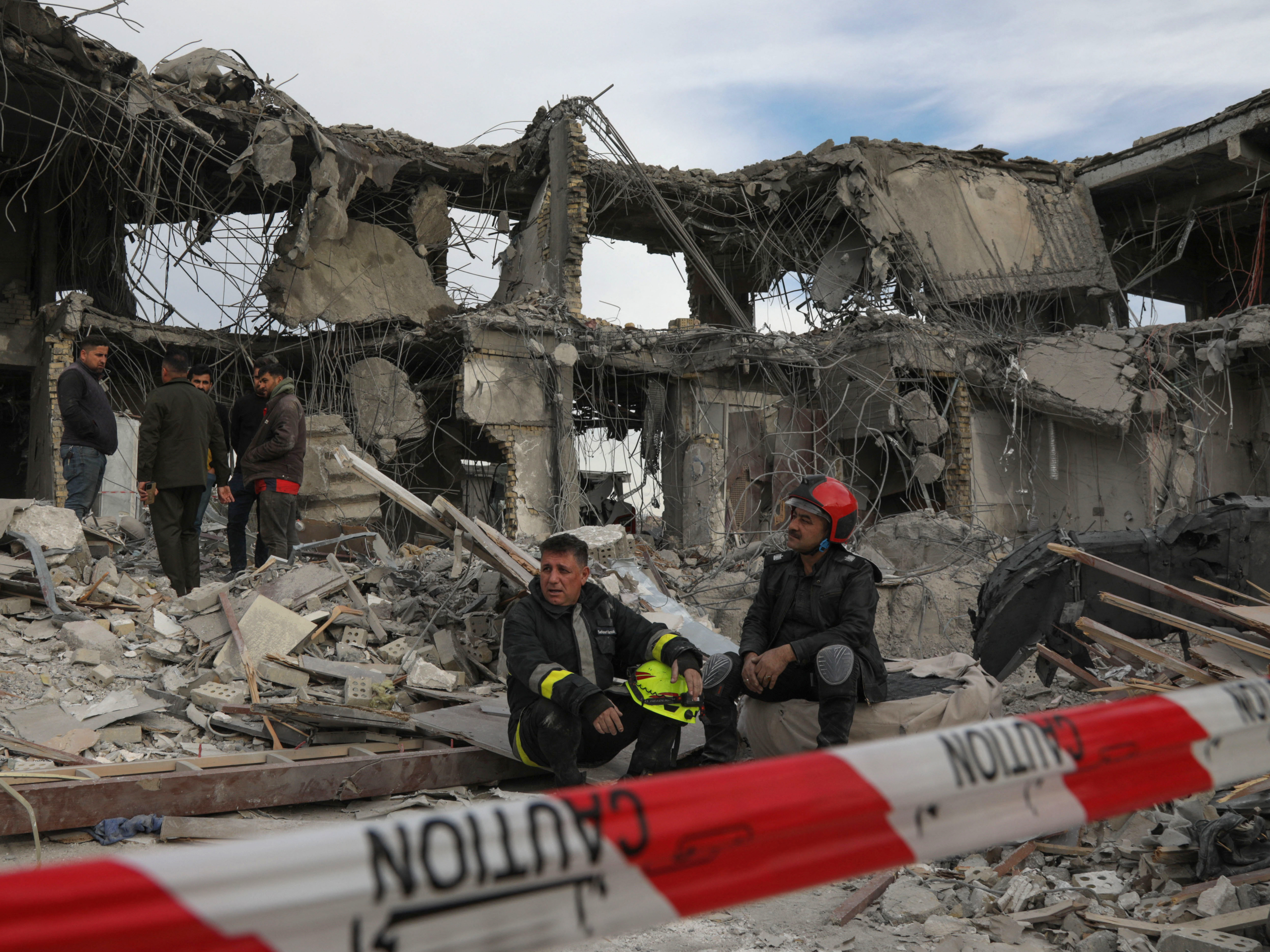 caption: A civil defense team carries out search-and-rescue operations in a damaged building following a missile strike launched by Iran on Irbil, the capital of northern Iraq's Kurdish region, on Tuesday.