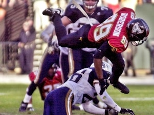 caption: The XFL is set for a surprising second life, kicking off games this weekend. In this file photo, San Francisco Demons wide receiver Brian Roberson jumps over Los Angeles Xtreme cornerback Dell McGee during a 2001 game.