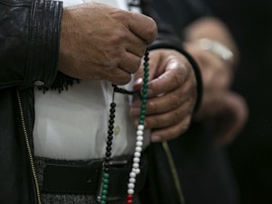 caption: A person identified as a family member of the slain 6-year-old boy holds prayer beads at a news conference at the Muslim Community Center on Chicago's northwest side on Sunday.