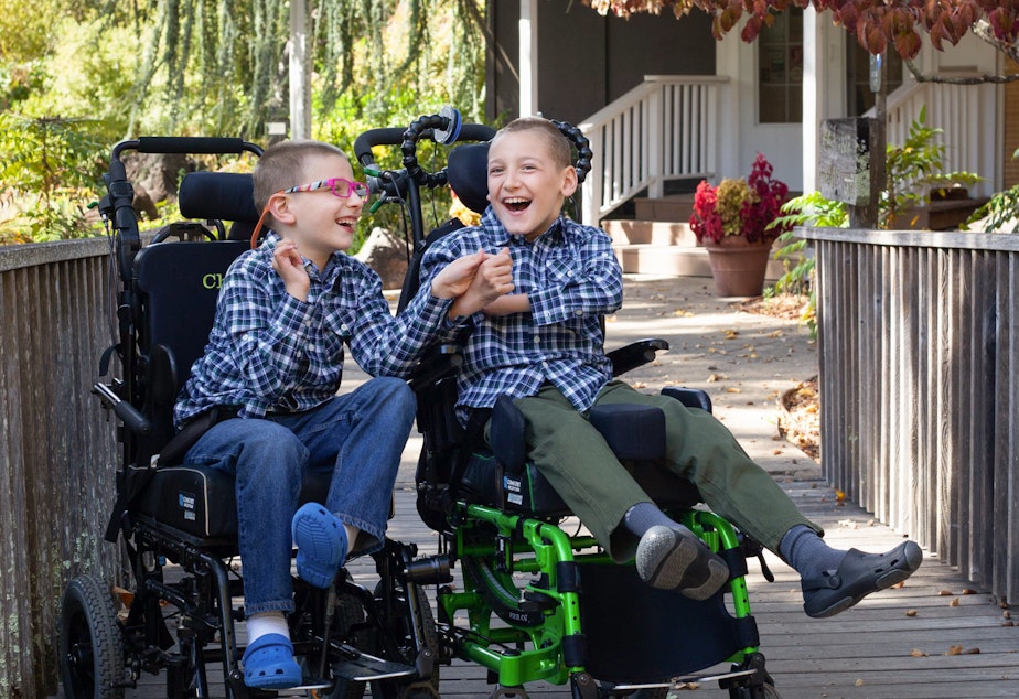 caption: Brothers Chase Miller (left), 10, and Carson Miller, 11, in November 2021. The two brothers have a rare genetic disorder and are immunocompromised. Their family has to practice extreme caution to prevent coronavirus exposures.