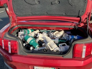 caption: The department released photos from the traffic stop showing a trunk full of the cups.