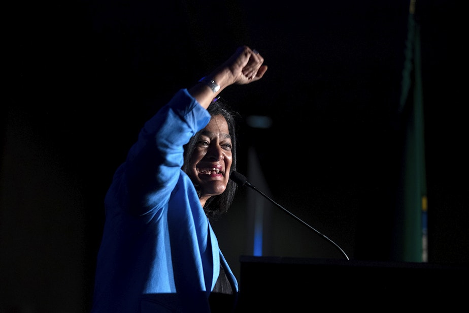 caption: Congresswoman Pramila Jayapal raises a fist in the air while speaking to supporters on Tuesday, November 8, 2022, during an election night party at the Westin in Bellevue. 