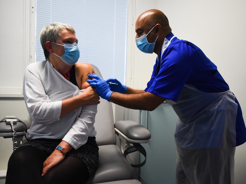 caption: Nurse Vash Deelchand inoculated Kate Bingham, chair of the U.K. government's vaccine task force, with a Novavax vaccine at the Royal Free Hospital in London in October.