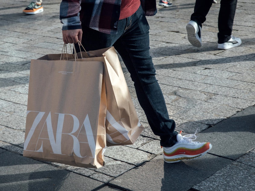 caption: A shopper carries Zara shopping bags in Paris. The fashion company said it regrets that some customers were offended by its latest ad campaign.