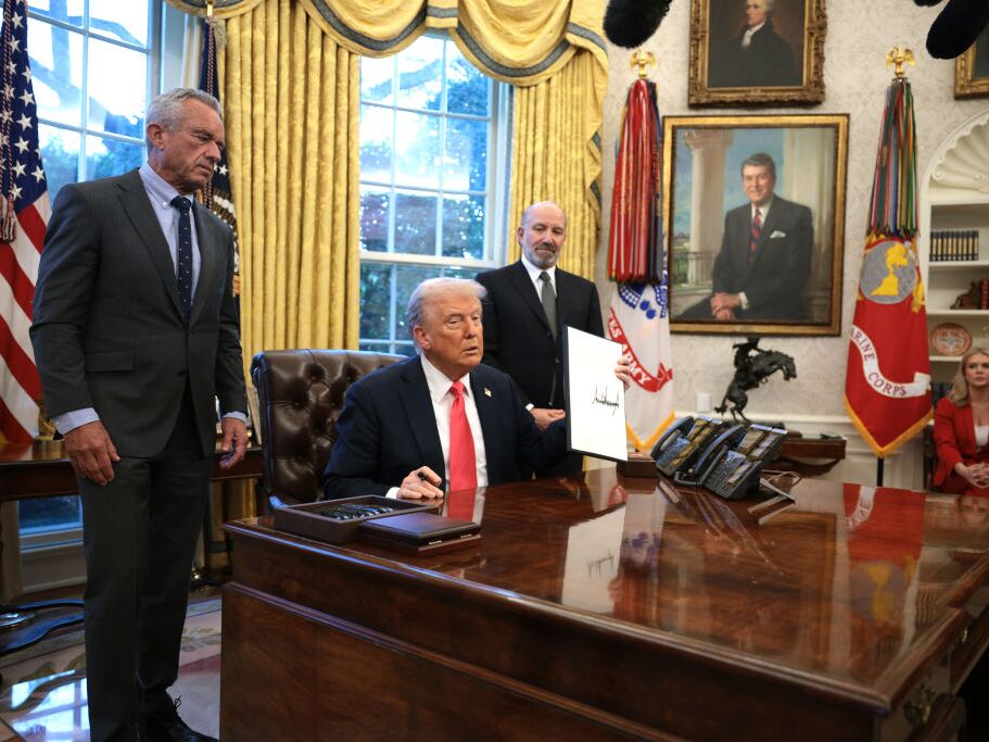 caption: President Trump, joined by Health and Human Services Secretary Robert F. Kennedy Jr. (left) and Commerce Secretary Howard Lutnick (right), signs an executive order on Feb. 25 on price transparency requirements for the health care industry.