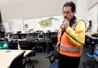caption: Mike Maloy, a volunteer with Seattle Auxiliary Services, at a Monday night radio check-in with other ham radio operators around the region.