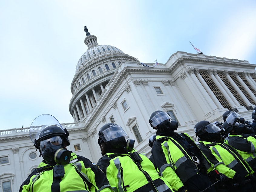 caption: Police stand in a line outside the U.S. Capitol on Jan. 6, 2021.