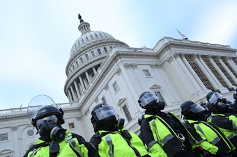 caption: Police stand in a line outside the U.S. Capitol on Jan. 6, 2021.
