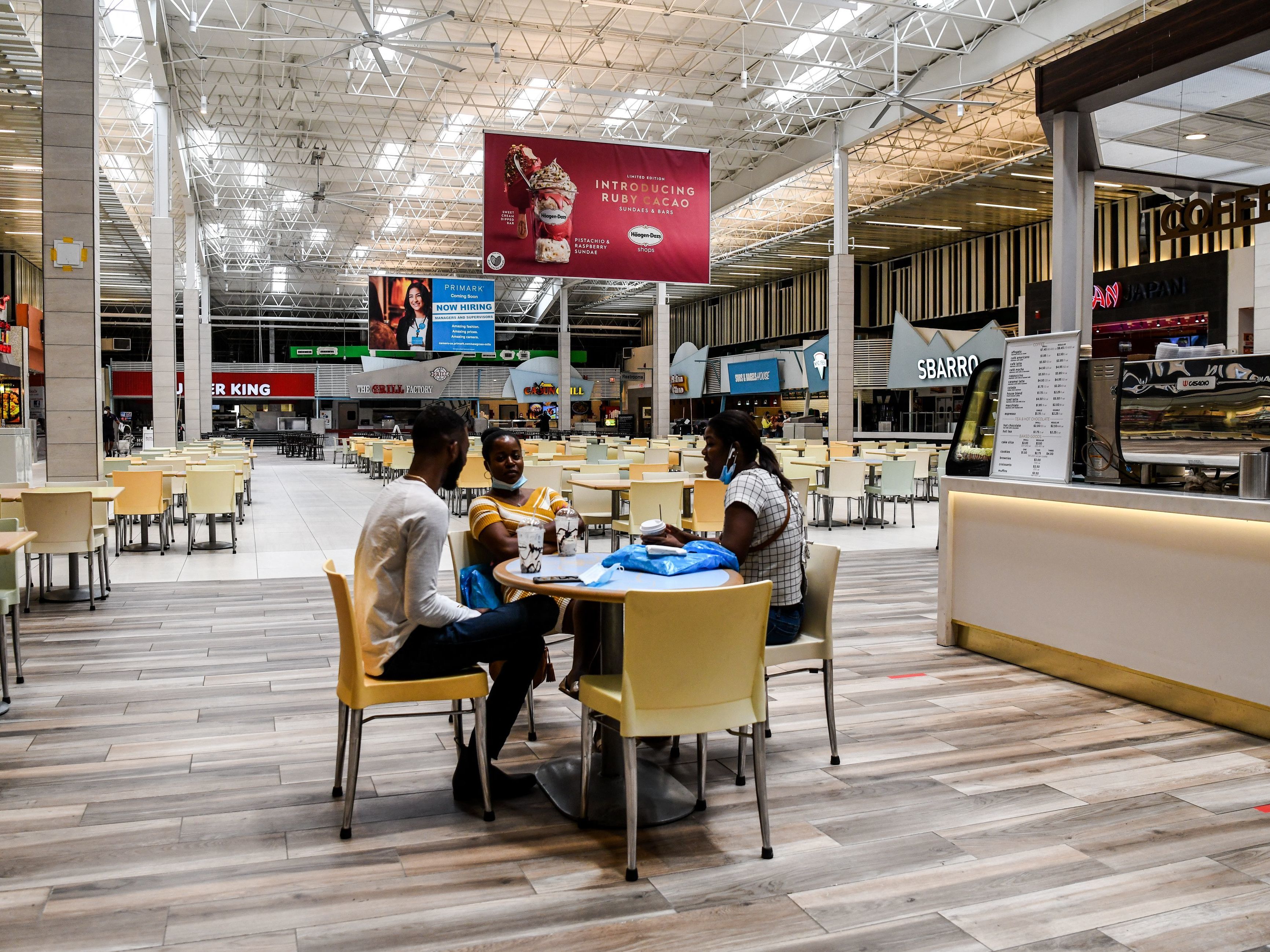 caption: People eat in a deserted food court inside a mall west of Fort Lauderdale, Fla., Monday. U.S. states have been easing restrictions on businesses ahead of Memorial Day, the traditional start of the summer vacation and outdoor season.