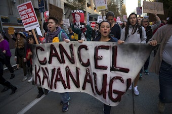 caption: Crowds march toward the Federal Building after leaving Westlake Park during the 'Cancel Kavanaugh - We Believe Survivors' march and rally on Thursday, October 4, 2018, in Seattle. Tap or click on the first image to see more. 