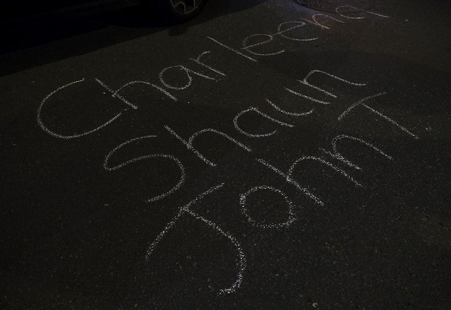 caption: The names Charleena, Shaun and John T. are shown written in chalk on the pavement on Monday, October 26, 2020, outside of the Seattle Police Department's West Precinct Building during the 150th day of protests for racial justice in Seattle. Charleena Lyles, Shaun Fuhr and John T. Williams were shot and killed by Seattle Police Officers. 