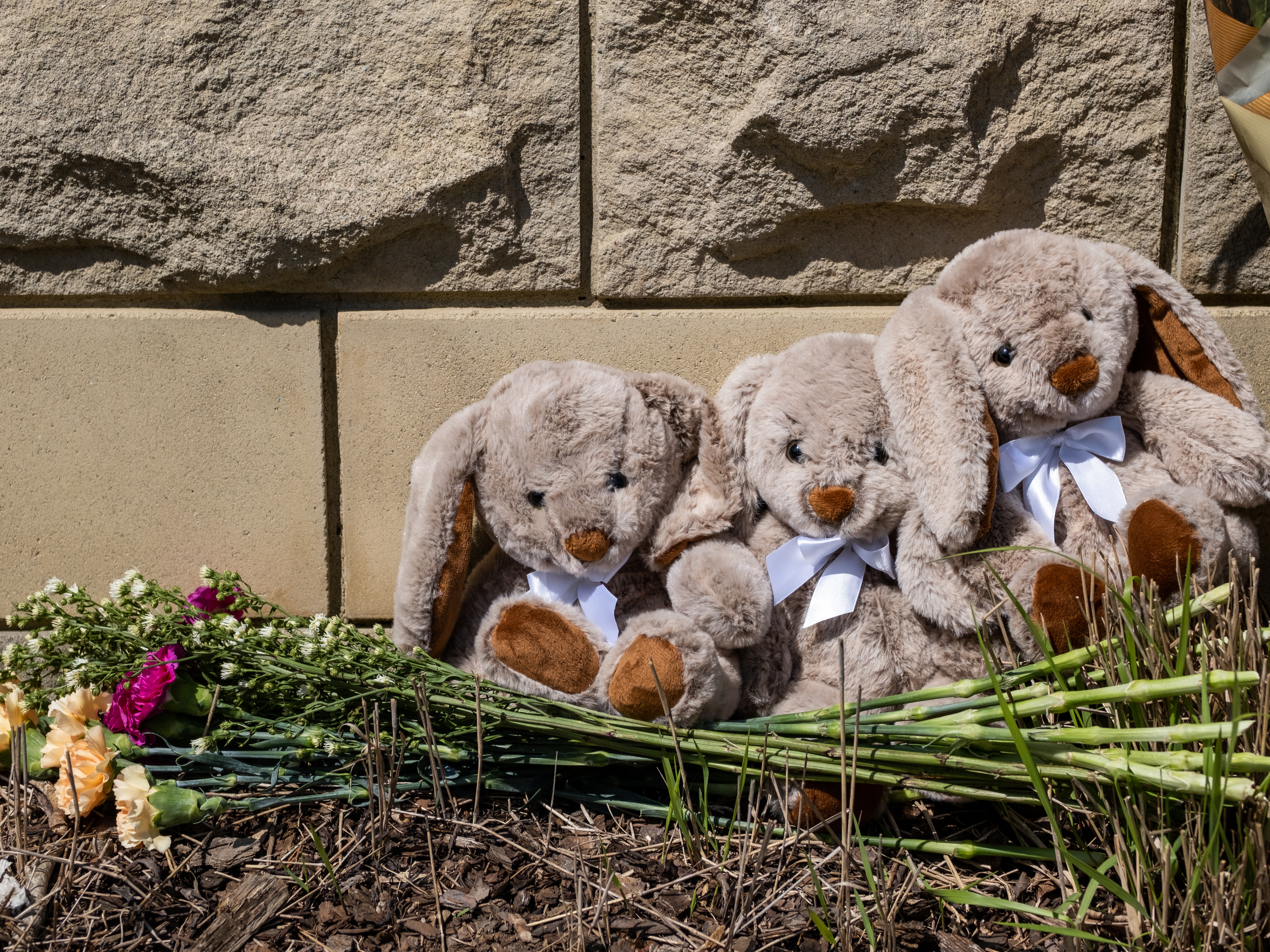 caption: Items are left at a makeshift memorial at the entrance of the Covenant School after the mass shooting.