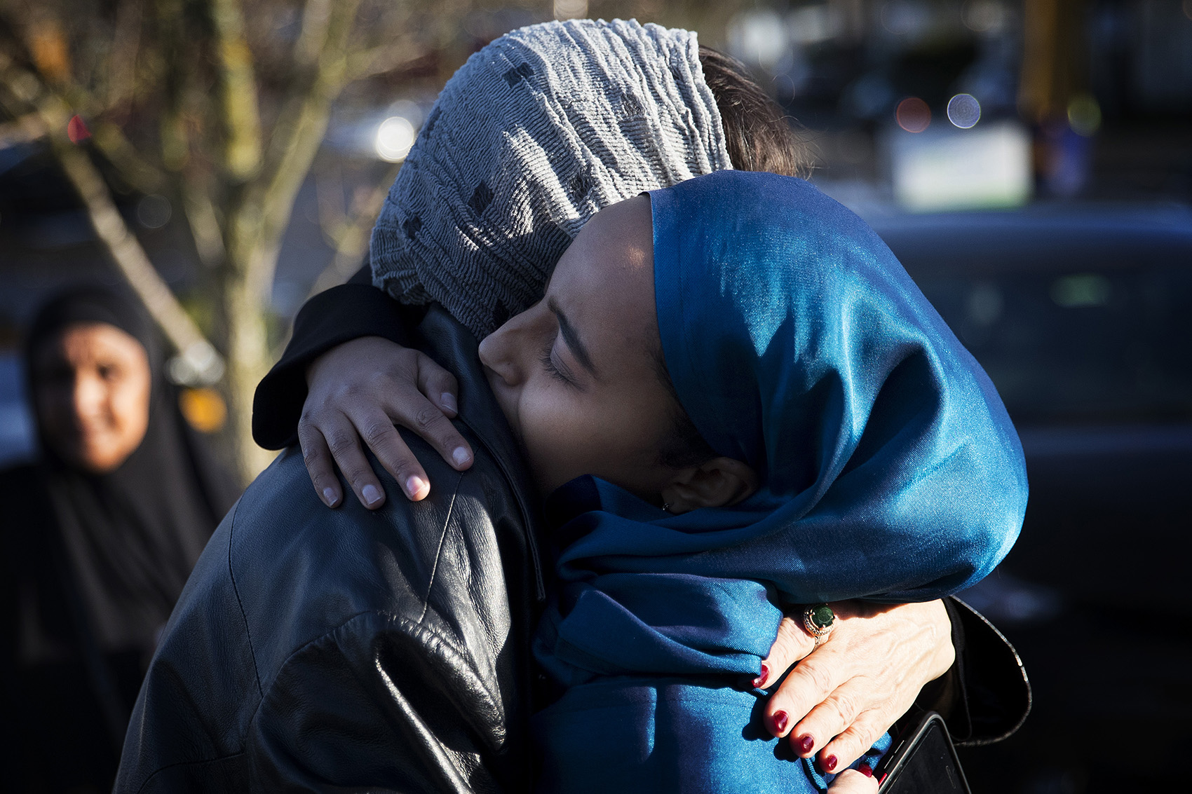 caption: Hamdi Mohamed, director of constituent services for representative Pramila Jayapal's office, right, hugs Samia El-Moslimany, left, after a gathering to remember the life of SeaTac city council member Amina Ahmed, who was killed in a car accident over the weekend, on Monday, December 10, 2018, at the Abu Bakr Islamic Center in Tukwila. 