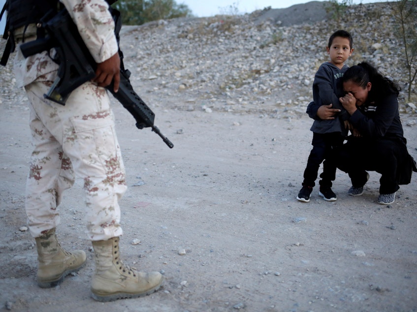 caption: Guatemalan migrant Lety Perez embraces her son Anthony while pleading with a Mexican National Guard member to let them cross into the United States, near Juárez, Mexico, on Monday.