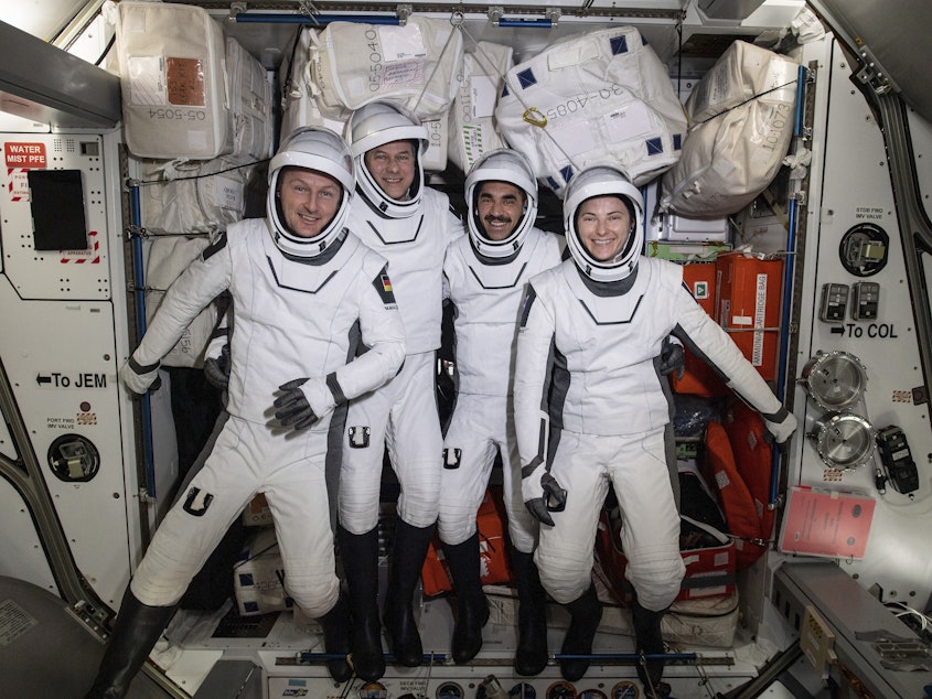 caption: In this photo made available by NASA, commercial crew astronauts, from left, European Space Agency astronaut Matthias Maurer, and NASA astronauts Tom Marshburn, Raja Chari, and Kayla Barron, pose for a photo in their Dragon spacesuits during a fit check aboard the International Space Station's Harmony module on April 21, 2022.