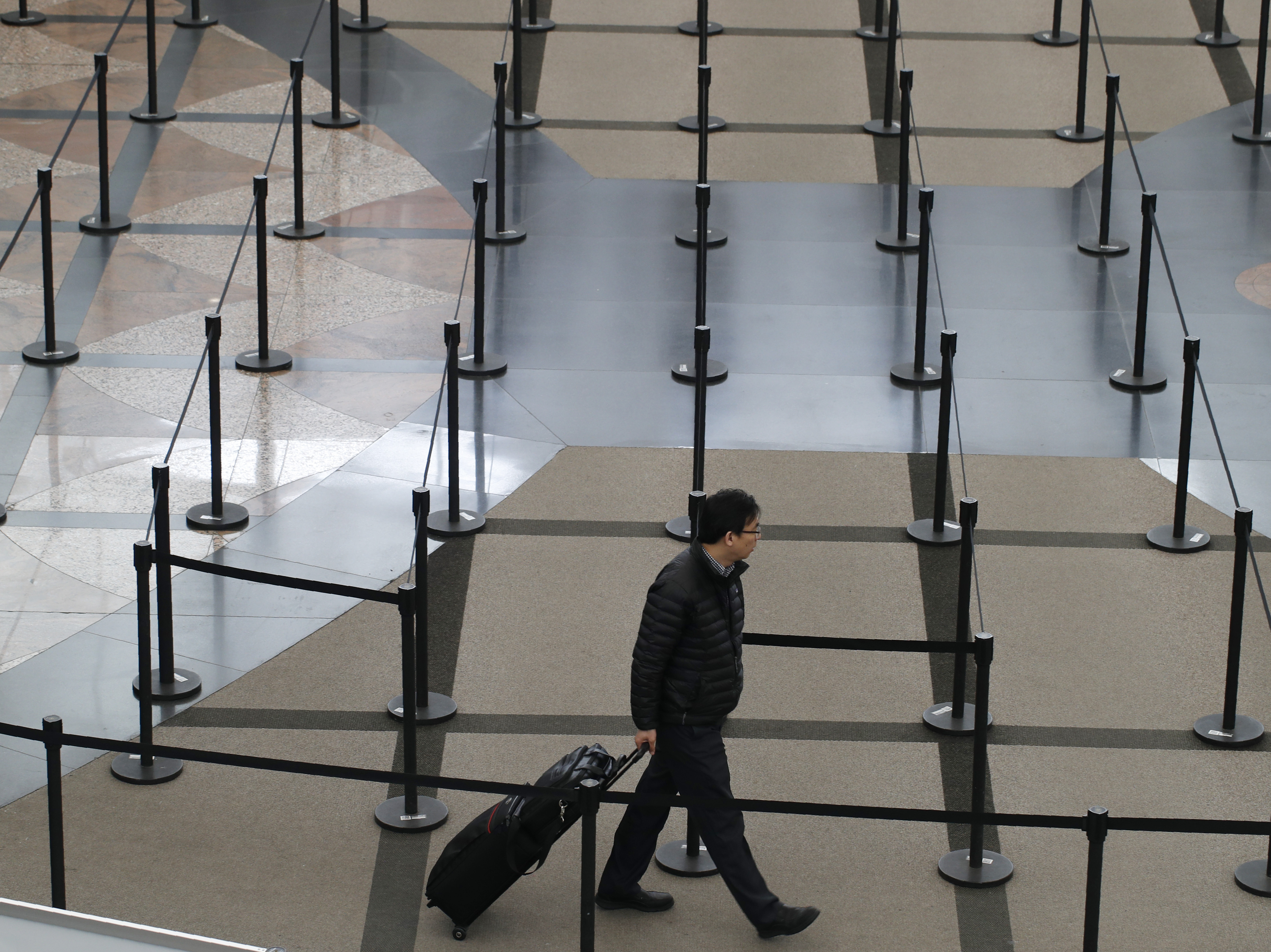 caption: A traveler finds no line to stand in at a security checkpoint at Denver International Airport on Friday.