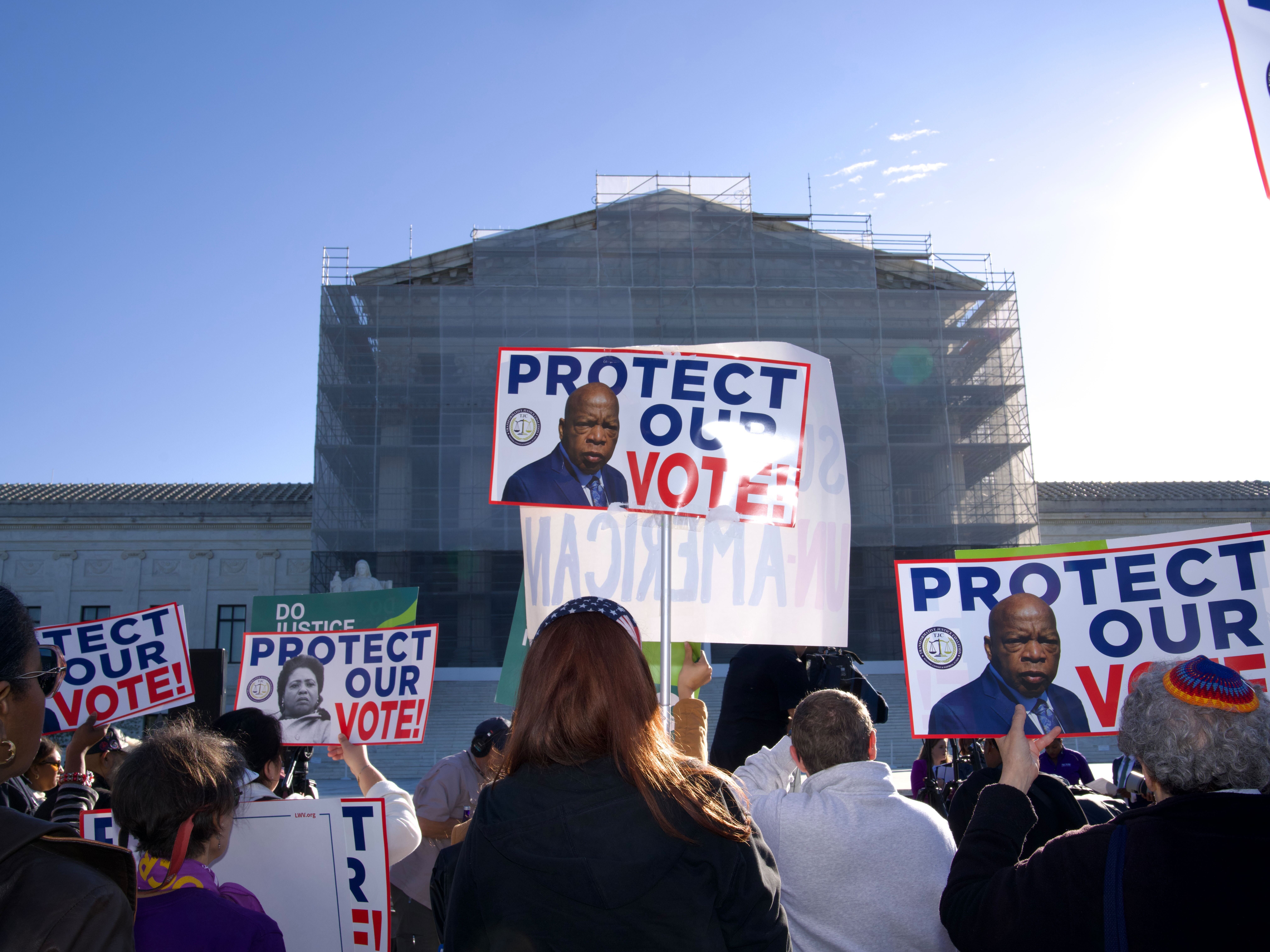 caption: Demonstrators holding signs in support of minority voting rights gather outside the U.S. Supreme Court in Washington, D.C., on Wednesday.