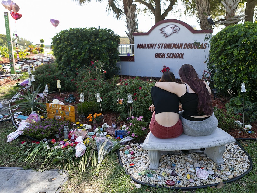 caption: Mourners visit a memorial outside of Marjory Stoneman Douglas High School in Parkland, Fla., in 2020, on the two-year anniversary of the Parkland shootings.
