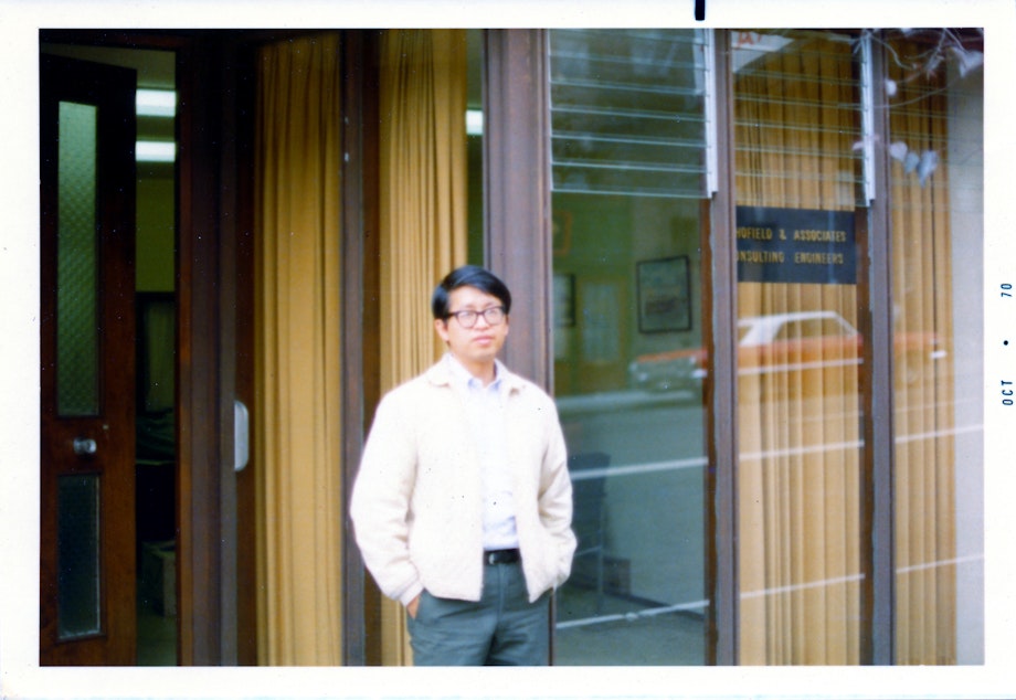 caption: Paul Woo stands in front of the Louisa Hotel building where he ran a law office (photo circa 1970).