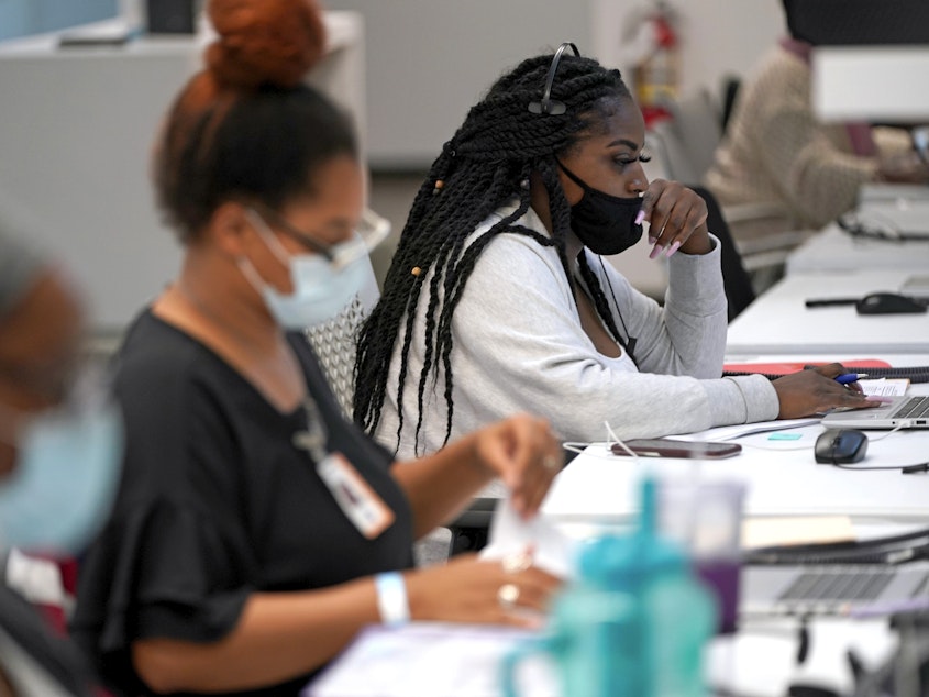 caption: Contact tracer Kandice Childress, right, works at Harris County Public Health contact tracing facility, on June 25.