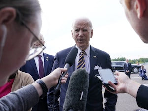 caption: President Biden speaks to reporters before boarding Air Force One in Vilnius, Lithuania. Biden was attending the NATO summit and was heading to Helsinki, Finland.