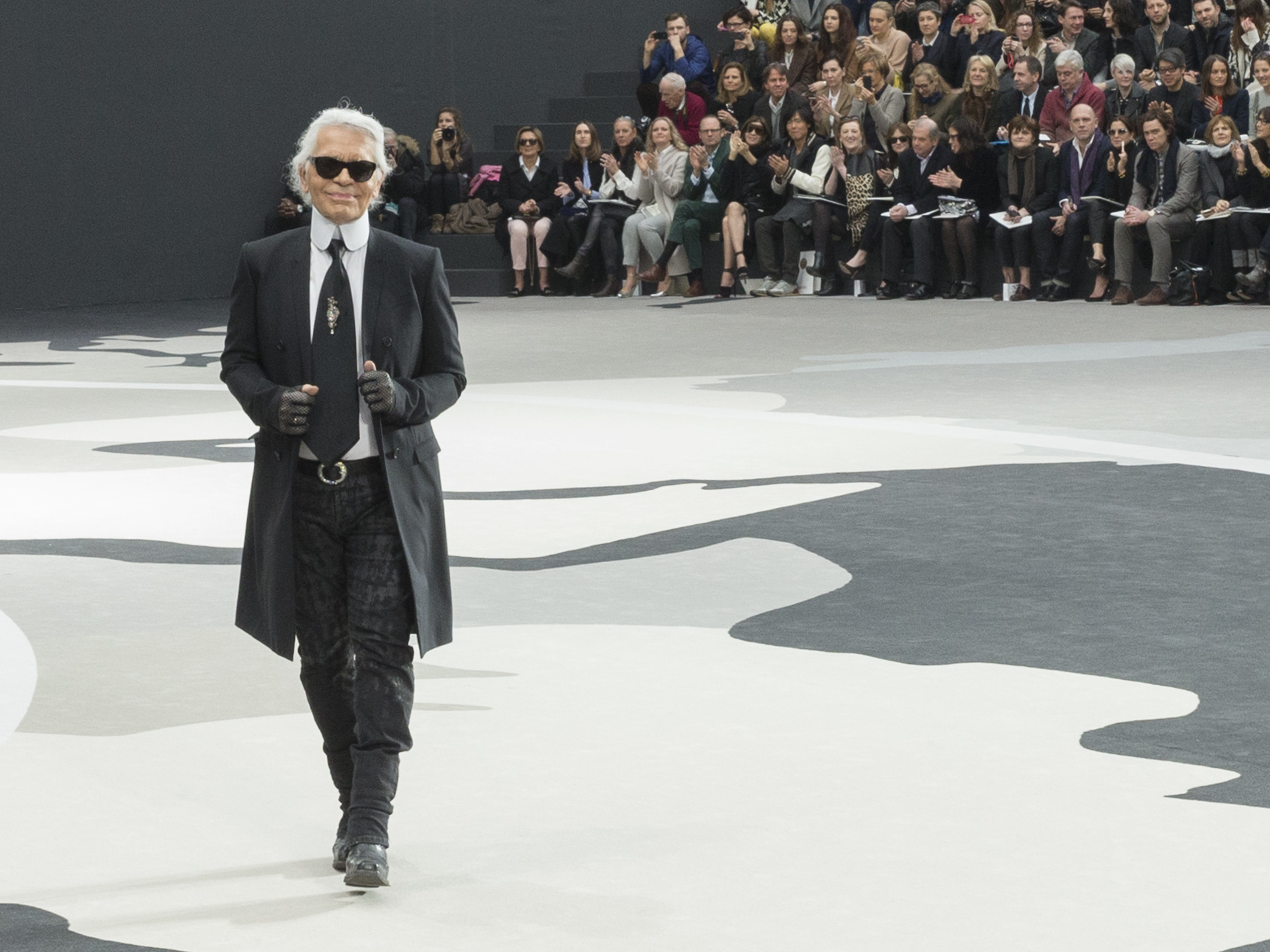 caption: Karl Lagerfeld acknowledges applause following a Chanel show in Paris in 2013.